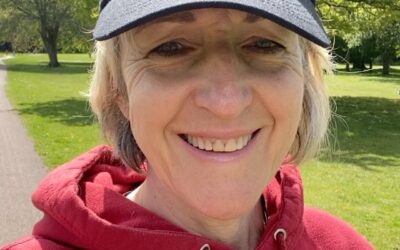 This is a selfie of Dr Sue Smith she is wearing her Walk with a Doc cap and her red hoodie and enjoying the sunshine.